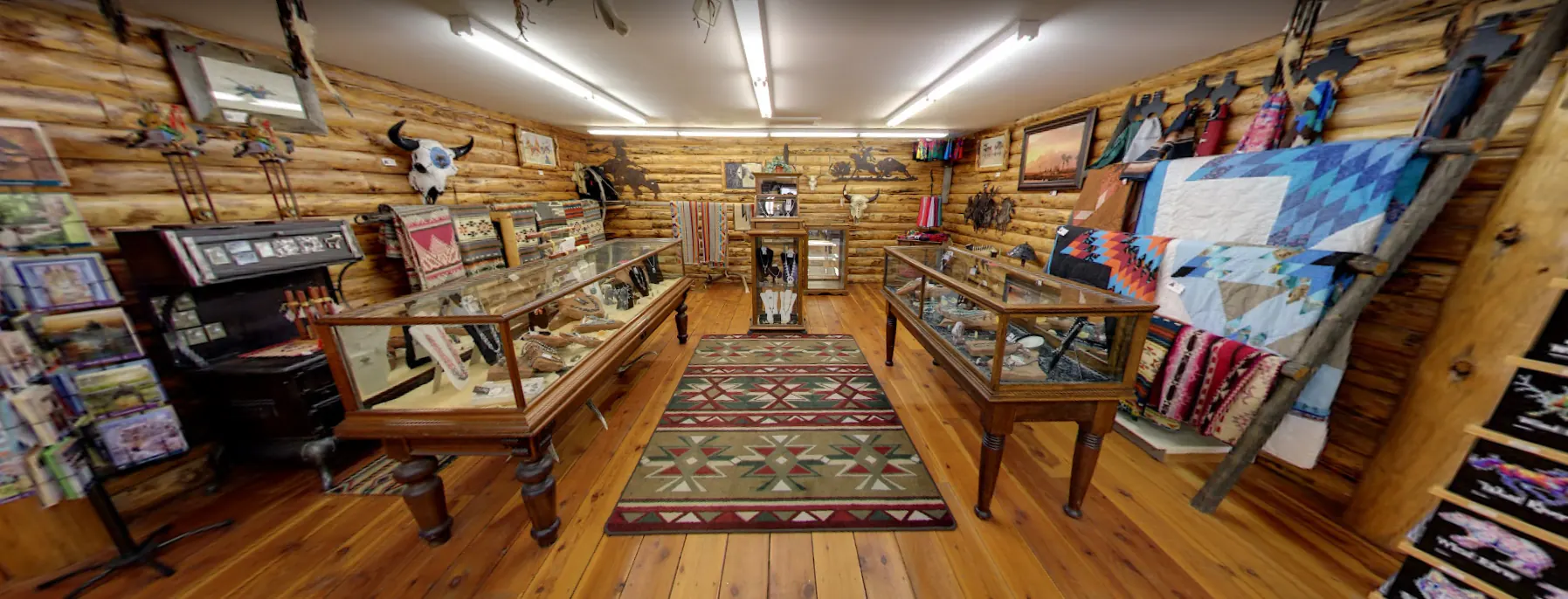 Interior showroom with display cases, blankets, and Western goods inside Wind River Trading Company
